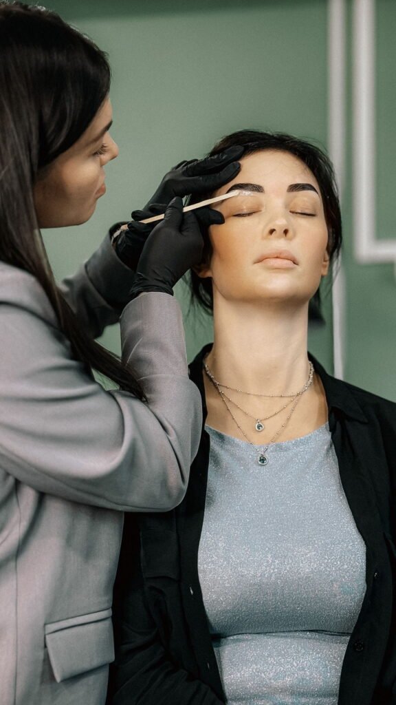 Specialist vormt de wenkbrauwen van een klant in een salon